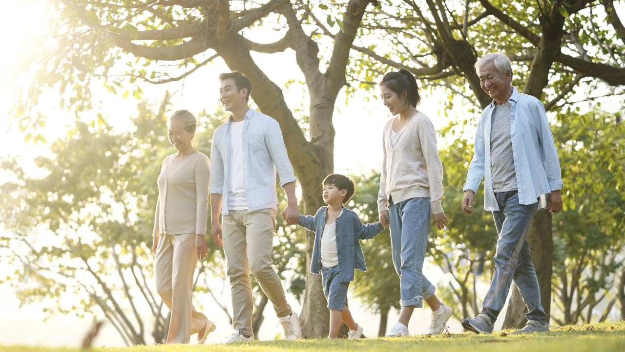 Three generation family walking outdoors in park